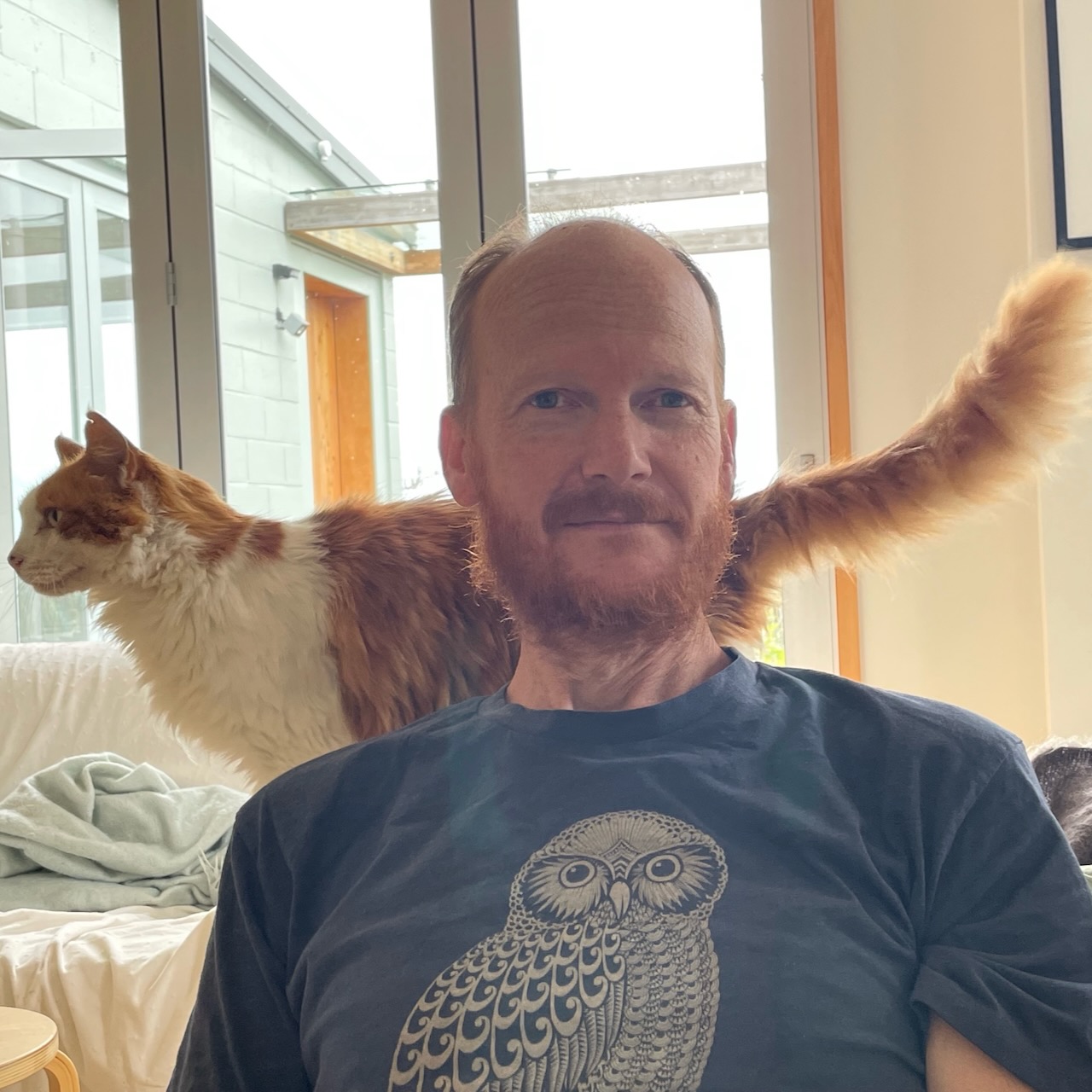 Adam Shand with a fluffy cat on his shoulder